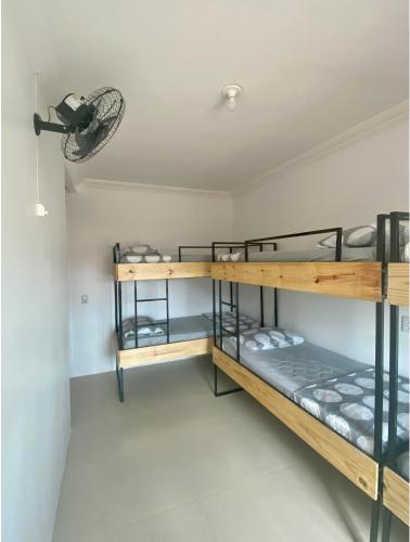 a room with three bunk beds and a fan at 4ª Cia Hostel e Pousada in Fortaleza