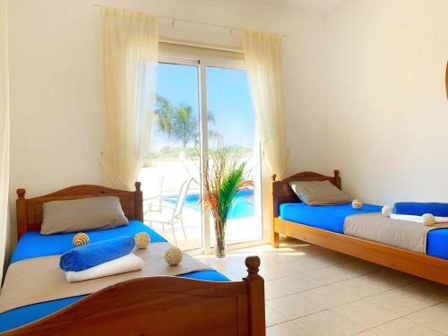 Duas camas num quarto com vista para o oceano em Carilisto Villas Big 4 Bedrooms in Center of Ayia Napa em Agia Napa