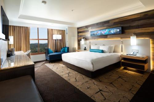 a hotel room with a bed and a desk and a couch at Chukchansi Gold Resort & Casino in Coarsegold