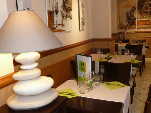 une lampe blanche assise sur une table dans un restaurant dans l'établissement Hôtel Concorde - Rodez Centre Ville, à Rodez