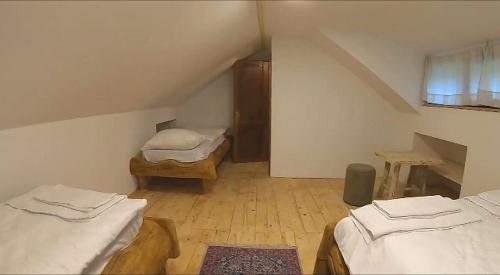 a attic room with two beds and a window at Apartman Romanija Dolina mira in Pale