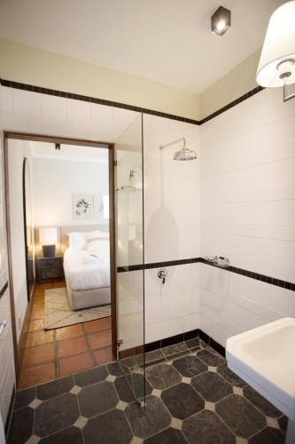 a bathroom with a glass shower and a bed at Beckhuis in Worcester