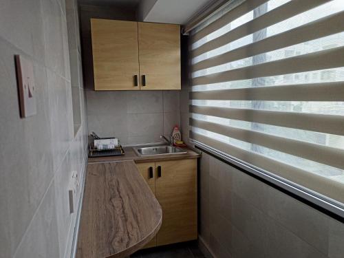 a small kitchen with a sink and a window with blinds at Studio in the center of Nicosia in Nicosia