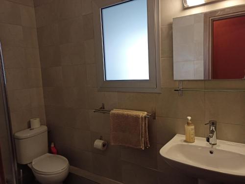 a bathroom with a toilet and a sink and a window at Studio in the center of Nicosia in Nicosia
