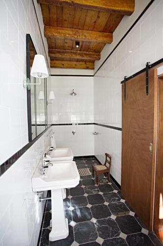 a bathroom with a white sink and a chair at Beckhuis in Worcester