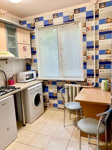 cocina con lavadora y mesa en Апартаменты в центре по проспекту Победы парковка рядом, en Cherníhiv