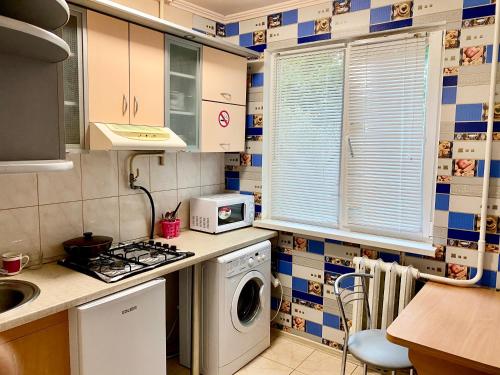 cocina con lavadora y microondas en Апартаменты в центре по проспекту Победы парковка рядом, en Cherníhiv