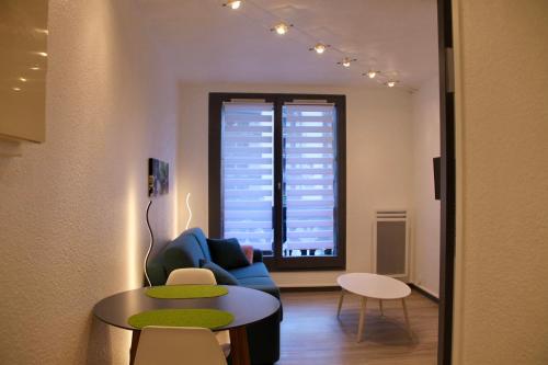ein Wohnzimmer mit einem blauen Sofa und einem Tisch in der Unterkunft Modern Studio Proche Centre Chamonix in Chamonix-Mont-Blanc