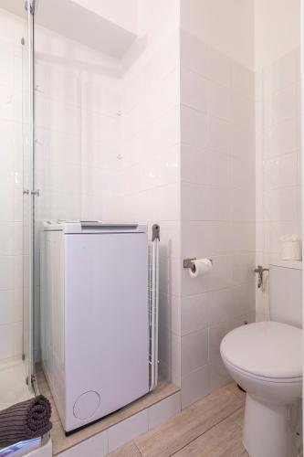 une salle de bain blanche avec toilettes et douche dans l'établissement Appartement Cham-Vue, à Chamonix-Mont-Blanc