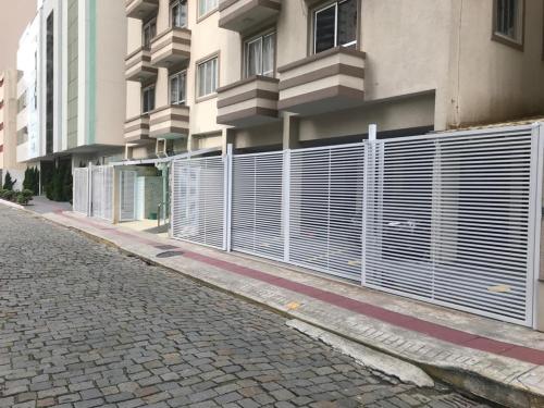 una valla frente a un edificio en Apartamento Balneário Camboriú - 2 quartos 80m do mar, en Balneário Camboriú