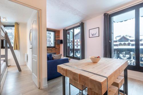 a living room with a wooden table and a blue couch at Appartement Cham-Vue in Chamonix