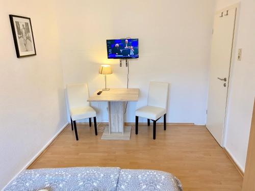 Habitación con mesa, 2 sillas y TV. en Gemütliches WG-Zimmer 2, zentral in Ravensburg en Ravensburg