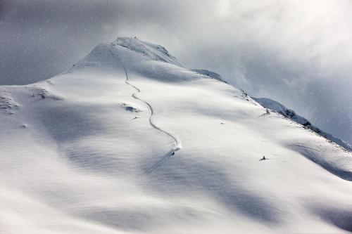 a mountain covered in snow with a trail on it at Das Haus Steger zu Stein in Kramsach
