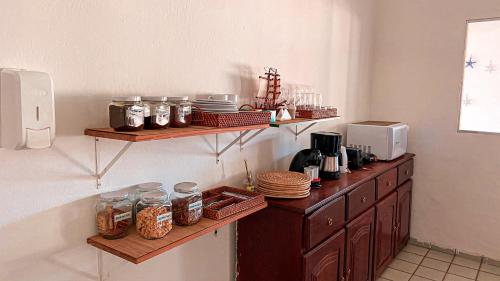 a kitchen with wooden shelves and jars of food at Pousada Brisa Mar in Fernando de Noronha