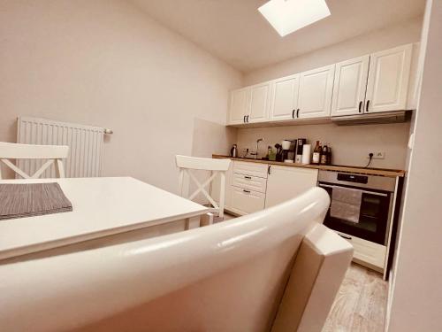 a kitchen with white cabinets and a white counter top at Ferienwohnungen Mey Haus zum Rosenstock in Erfurt
