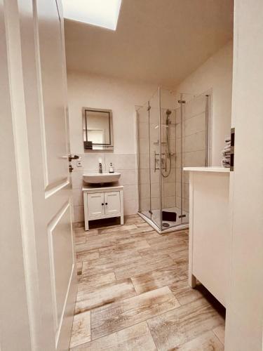 a white bathroom with a sink and a shower at Ferienwohnungen Mey Haus zum Rosenstock in Erfurt
