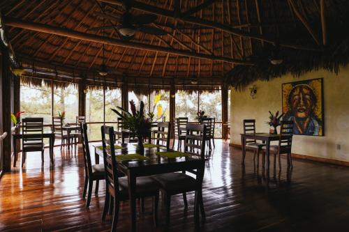 a restaurant with tables and chairs and a painting on the wall at Gaia Riverlodge in San Ignacio