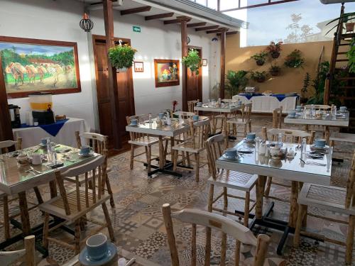 a dining room with tables and chairs in a restaurant at La Estancia Hotel Boutique in Salamina