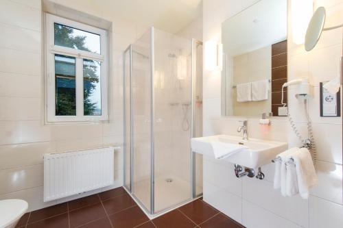 a white bathroom with a sink and a shower at Hotel Greive in Haren