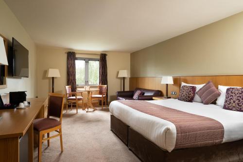 una camera d'albergo con un grande letto e una scrivania di Belmore Court & Motel a Enniskillen