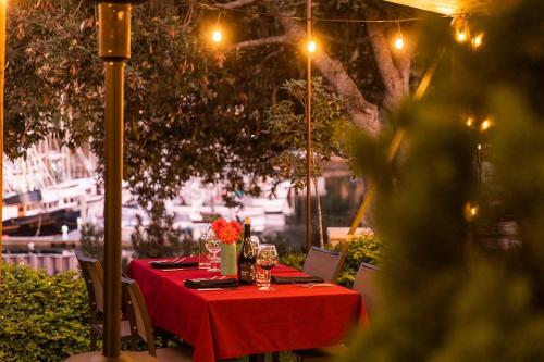 a table with a red table cloth and flowers on it at Noyo Harbor Inn in Fort Bragg