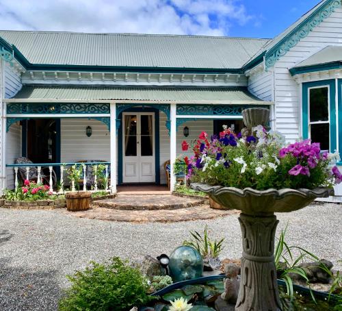 a house with a vase of flowers in front of it at Karamana Homestead (1872) in Coromandel Town