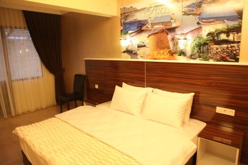 um quarto com uma cama e um quadro na parede em Lucid Hotel em Esmirna
