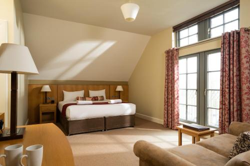 een hotelkamer met een bed en een bank bij Lodge at Lough Erne in Enniskillen