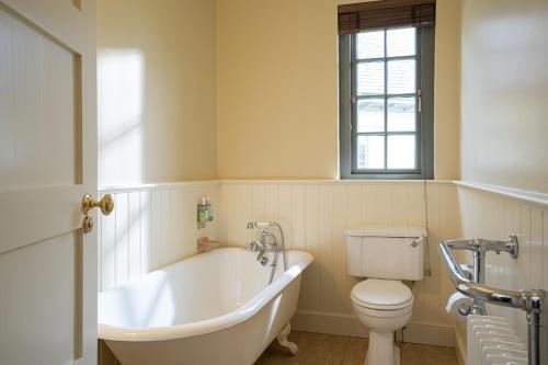 La salle de bains blanche est pourvue d'une baignoire et de toilettes. dans l'établissement Lodge at Lough Erne, à Enniskillen