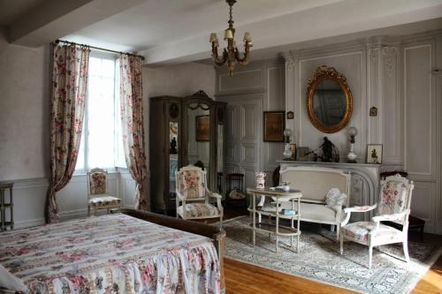 Schlafzimmer mit einem Bett, einem Tisch und Stühlen in der Unterkunft Le Clos du Prince in Quintin