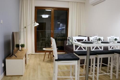 een woonkamer met een tafel en een eetkamer bij Apartament Morski in Krynica Morska