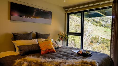 a bedroom with a bed with a large window at Diana Alpine Lodge in Falls Creek