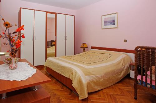 a bedroom with a bed and a table with a vase at Apartments Julija in Vela Luka