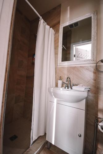 a bathroom with a sink and a shower with a mirror at Bellas Castle in Morden