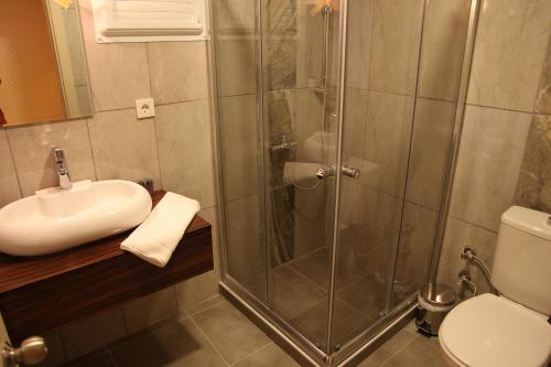 y baño con ducha, lavabo y aseo. en Lucid Hotel en İzmir