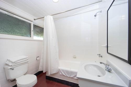 a white bathroom with a toilet and a sink at Hotel Salto Del Laja in Los Ángeles