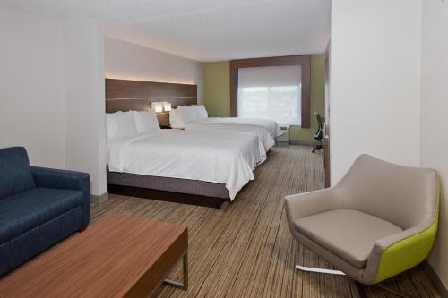 Holiday Inn Express Hotel & Suites Dothan North, an IHG Hotel في دوثان: غرفة فندقية بسريرين وكرسي