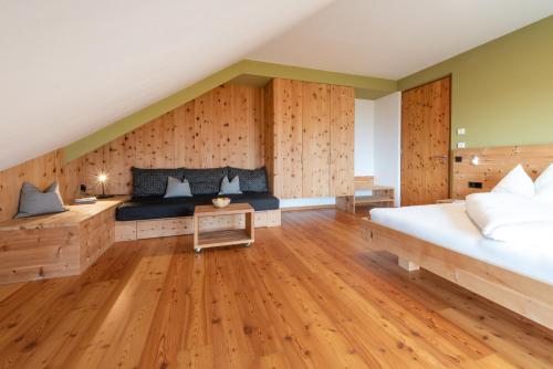 um quarto com uma cama grande e paredes de madeira em Biobauernhof St. Quirinus em Caldaro