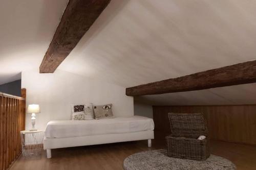 une chambre avec un lit blanc et une chaise dans l'établissement Le 68b, à Carcassonne