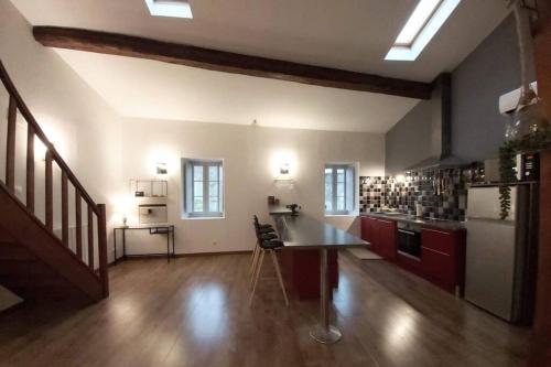 une grande cuisine avec des placards rouges et un réfrigérateur blanc dans l'établissement Le 68b, à Carcassonne