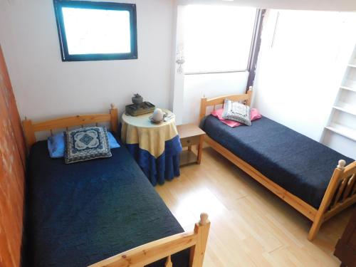 a room with two beds and a table in it at Hostal Pampaloja Antof in Antofagasta