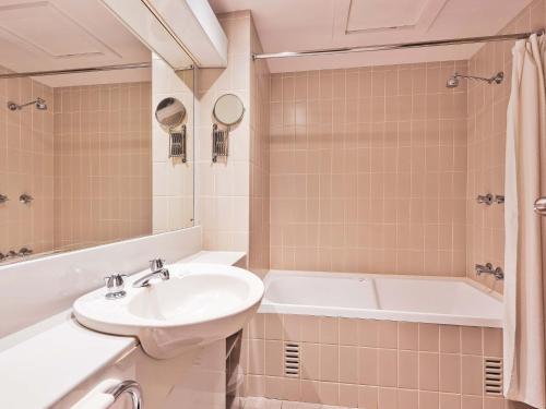 ein Badezimmer mit einem Waschbecken und einer Badewanne in der Unterkunft Lantern 1 Bedroom Balcony with expansive view in Thredbo