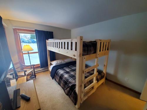 ein Schlafzimmer mit Etagenbett und Schreibtisch in der Unterkunft Trail Creek: Walk to lifts, ski home! Closest unit to lifts, ski home trail, sports center in Killington