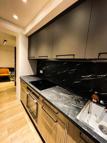 - une cuisine avec un plan de travail noir et un évier dans l'établissement RenTcik, à Cannes