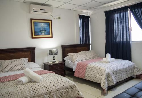 a bedroom with two beds and a window at Hotel Valeritos in Playas