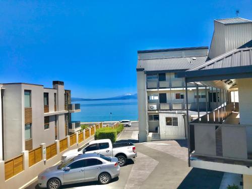 two cars parked in a parking lot in front of a building at Tui Oaks Motel in Taupo