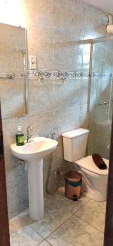 a bathroom with a sink and a toilet and a shower at Pousada Esquina de Lavras in Lavras Novas