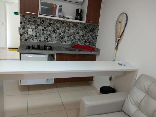 uma cozinha com um balcão branco e uma raquete de ténis em Laguna Beach Flat -205 em Porto de Galinhas