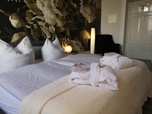a bedroom with a bed with towels on it at Pension Zur Alten Post in Havelberg