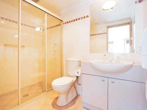 uma casa de banho com um WC, um lavatório e um chuveiro em Lhotsky 2 Bedroom apartment with balcony mountain views and BBQ em Thredbo